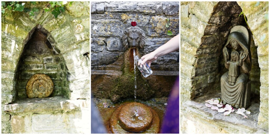 Woman filling a water bottle at the sacred Lion's Head fountain with statues at Chalice Well in Glastonbury