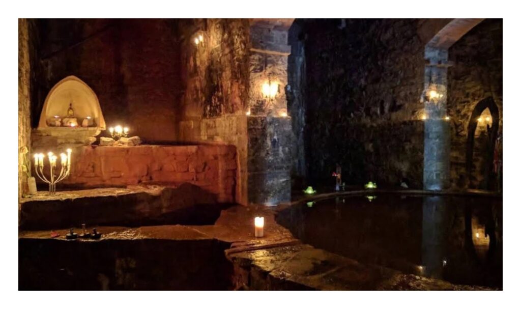 Candlelit White Spring Temple with the sacred water basin in Glastonbury